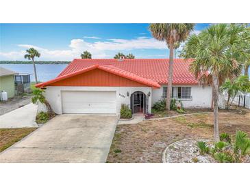 Charming single-story home with red tile roof, attached garage, and landscaping at 33620 Picciola Dr, Fruitland Park, FL 34731
