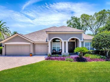 Charming single-story home featuring a three-car garage, manicured lawn, and arched entryway at 3775 Brantley Place Cir, Apopka, FL 32703