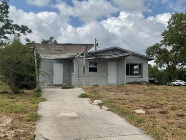 Modest single-Gathering home with a cinder block exterior and an unfinished pergola at 447 E Desoto St, Clermont, FL 34711
