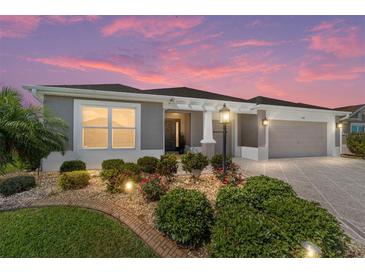 Charming single-story home with landscaped front yard and a two-car garage at 560 Caputo Ct, The Villages, FL 32163