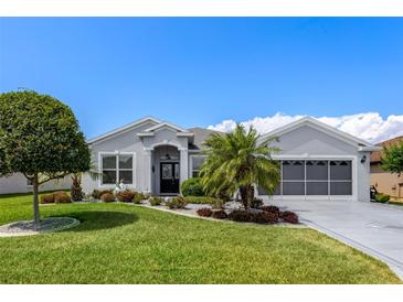 Beautiful single story home with well-manicured landscaping and a charming front yard at 5818 Greenbriar Loop, Leesburg, FL 34788