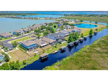 An aerial view of a waterfront community featuring homes with docks on a beautiful lake at 722 Barefoot Bay Loop, Clermont, FL 34736