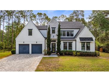 Stunning two-story home with a manicured lawn, gray driveway, and black trimmed windows and doors at 9134 Mossy Oak Ln, Clermont, FL 34711