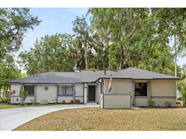 Charming single-story home with a well-maintained lawn, mature trees, and a welcoming driveway at 227 Oak Rd, Winter Springs, FL 32708