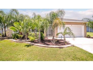 Charming home with well-manicured lawn and lush tropical landscaping around the entrance at 30 Olive Cir, Ocala, FL 34472