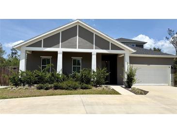 Charming single-Gathering home features a well-manicured lawn and inviting covered front porch at 31857 Dahlia Ct, Eustis, FL 32736