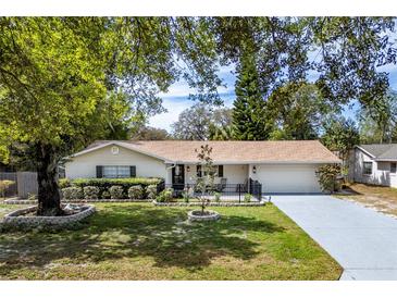 Charming home with a well-manicured lawn, brick accents and mature trees at 3430 Laurel Dr, Mount Dora, FL 32757