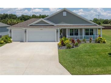 Charming home featuring a well-manicured lawn and a convenient two-car garage at 3532 Thorne Path, Oxford, FL 34484