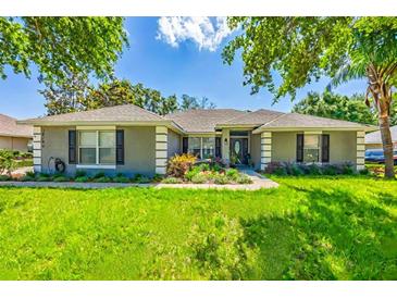 Charming single-story home with a well-manicured lawn and colorful landscaping around the entrance at 36700 Oconee Ave, Eustis, FL 32736