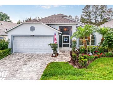 Charming single-story home with a well-manicured lawn, a two-car garage, and beautiful landscaping at 4087 Capland Ave, Clermont, FL 34711