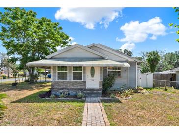 Charming single-story home with well-maintained landscaping and a welcoming front porch with awning at 506 Richard St, Leesburg, FL 34748