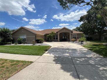 Stunning single-story home with a beautifully landscaped front yard and a spacious concrete driveway at 9010 Laurel Ridge Dr, Mount Dora, FL 32757