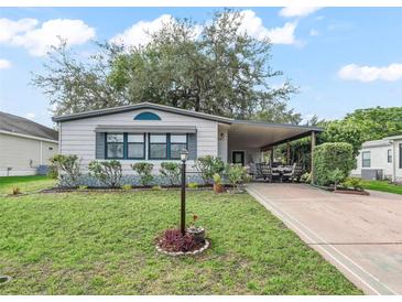 Charming single-story home with manicured lawn, covered parking, and cozy front garden at 941 Tarrson Blvd, Lady Lake, FL 32159