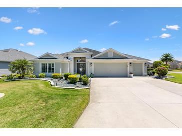 Charming single-story home featuring a well-manicured lawn and a three-car garage at 1182 Allaire Loop, The Villages, FL 32163