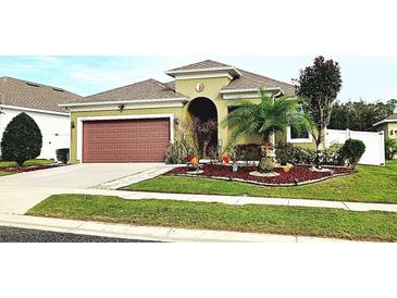 Charming single-story home with a well-manicured lawn, mature landscaping, and an attached two-car garage at 1231 Merion Dr, Mount Dora, FL 32757