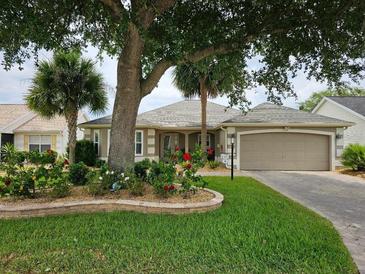 Charming one-story home featuring a well-manicured lawn, lovely garden, and attached two car garage at 2015 Palo Alto Ave, The Villages, FL 32159
