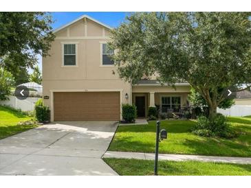 Two-story home featuring a two-car garage and a well-manicured lawn at 356 Giovani Blvd, Clermont, FL 34715