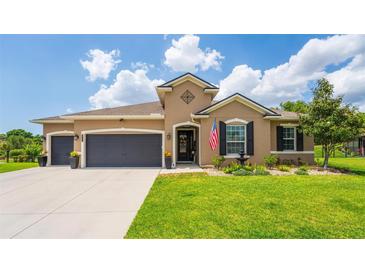 Charming single Gathering home with a well-manicured lawn, two car garage and beautiful landscaping at 3733 Statham Dr, Apopka, FL 32712