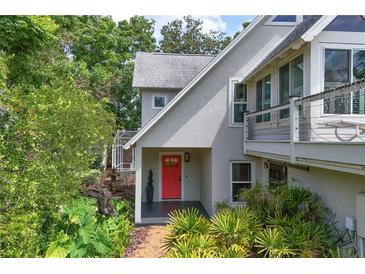 Charming home featuring a red front door and lush, well-maintained landscaping at 421 W 10Th Ave, Mount Dora, FL 32757