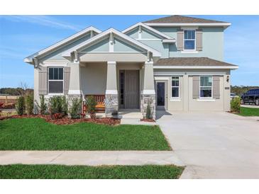 Charming two-story home featuring stone accents, a covered porch, and well-manicured landscaping at 5463 Nickerbean St, Apopka, FL 32712