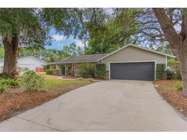 Charming single story home featuring an attached two car garage, and a spacious front yard with mature landscaping at 8410 Lake Bosse Dr, Orlando, FL 32810