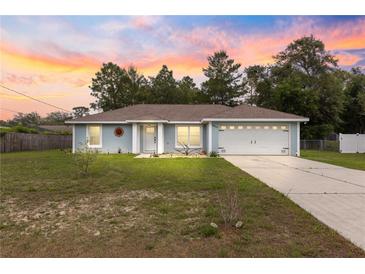 Charming single-story home with manicured lawn and welcoming two-car garage, perfect for suburban living at 8869 Se 159Th Pl, Summerfield, FL 34491