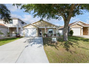 Charming single-story home featuring a well-maintained yard and inviting front porch with swing at 12430 Ne 52Nd Loop, Oxford, FL 34484