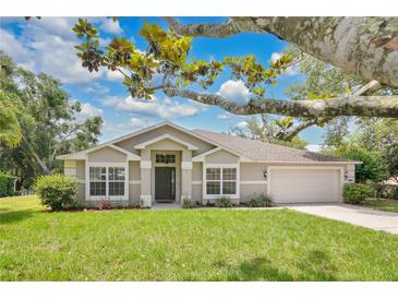 Charming single-story home with a lush green lawn and well-maintained landscaping, enhancing its curb appeal at 12512 Lake Ridge Cir, Clermont, FL 34711