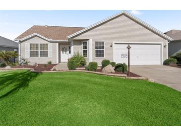 Charming single-story home featuring a well-manicured lawn and tidy landscaping at 17916 Se 87Th Melrose Ct, The Villages, FL 32162
