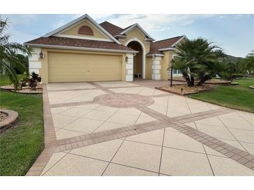 Beautiful home featuring a decorative driveway, a two-car garage, and a well-maintained lawn at 2918 Canyon Ave, The Villages, FL 32163