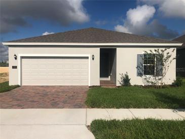 Charming single-story home featuring a two-car garage, landscaped yard and neutral color palette at 4102 Penelope Ave, Lake Wales, FL 33859
