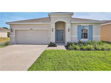 Charming single-story home with a two-car garage, well-maintained lawn and beautiful, complimentary landscaping at 524 Silver Palm Dr, Haines City, FL 33844