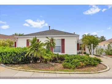 Charming home featuring well-maintained landscaping, red shutters, and a circular driveway at 8932 Se 168Th Sedgwick Pl, The Villages, FL 32162