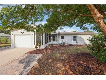 Charming single-story home with a well-manicured front yard and a covered porch at 1 Aberdeen Cir, Leesburg, FL 34788
