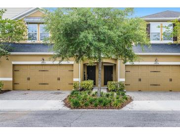 Two-story townhome featuring a symmetrical facade, dual garage doors, and a well-maintained front garden at 14430 Desert Haven St # 4302, Windermere, FL 34786
