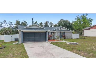 Charming single-story home featuring a well-manicured lawn, brick accents, and an attached two-car garage at 2304 Clementine Trl, Clermont, FL 34714