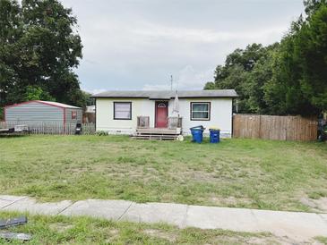Charming single-story home with a red front door, small porch and a large front yard at 24531 County Road 561, Astatula, FL 34705