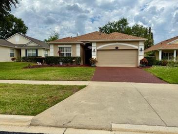 Charming single-story home with a well-maintained lawn and a brick-paved driveway at 3083 Pinnacle Ct, Clermont, FL 34711