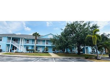 Inviting two-story condo building with a blue exterior, balconies, and mature landscaping at 3107 Sun Lake Ct # A, Kissimmee, FL 34747
