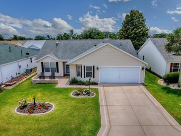 Charming single-story home with a well-manicured lawn and two-car garage on a sunny day at 3432 Fairfield St, The Villages, FL 32162