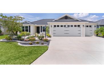 Charming single-story home with a well-manicured lawn, a two-car garage, and beautiful landscaping at 3745 Causey Ct, The Villages, FL 32163