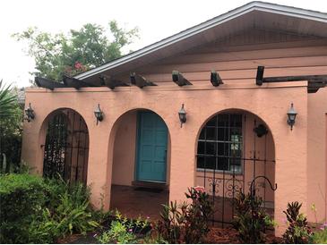 Charming home entrance with stucco arches, wrought iron details, and a colorful front door at 507 Bates Ave, Eustis, FL 32726