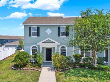 Charming townhouse with a well-manicured lawn, walkway, and decorative shrubbery at 534 Juniper Springs Dr, Groveland, FL 34736