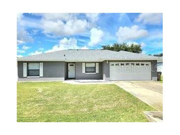 Charming single-story home with a well-manicured lawn and a two-car garage at 607 Baldwin Dr, Kissimmee, FL 34758