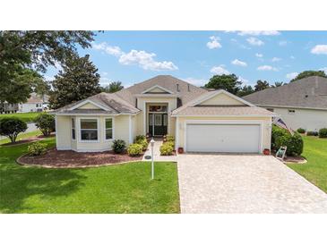 Charming single Gathering home featuring a well-maintained lawn, 2 car garage and covered entryway at 616 Hartford Ln, The Villages, FL 32162