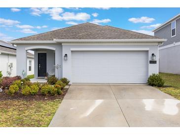 Charming single-story home with a well-manicured lawn and attached two-car garage at 6816 Perch Hammock Loop, Groveland, FL 34736
