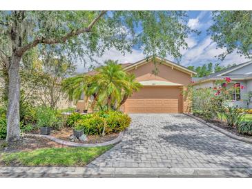 Charming single-story home with a well-manicured lawn and a paver driveway at 684 Grand Canal Dr, Kissimmee, FL 34759