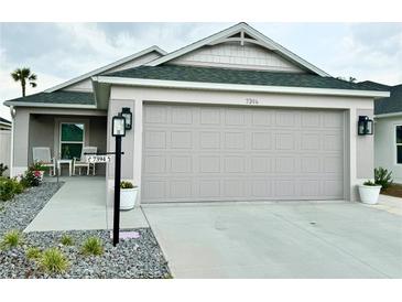 Charming home showcasing a clean two-car garage and well-maintained front yard with manicured rock landscaping at 7394 Lussier Ct, The Villages, FL 34762