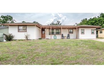 Charming single-story home with a cozy covered porch and well-maintained front lawn at 800 Jefferis Ct, Eustis, FL 32726