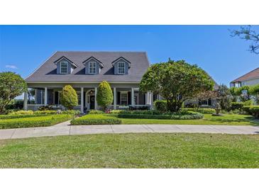 Beautiful exterior showcasing a well-maintained lawn and landscaped garden in front at 9648 Weatherstone, Windermere, FL 34786